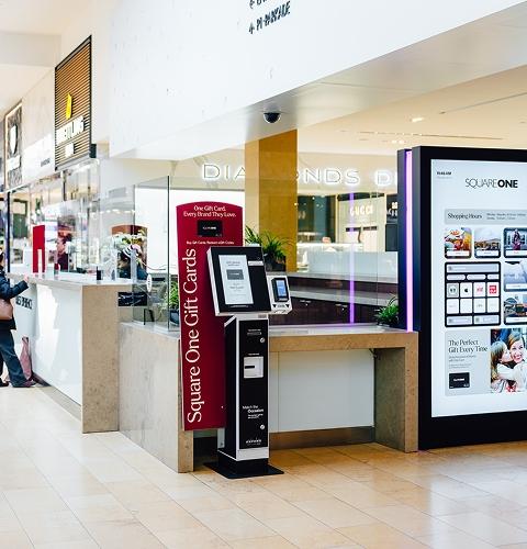 Gift card kiosk and digital mall directory at Square One shopping centre with shoppers nearby