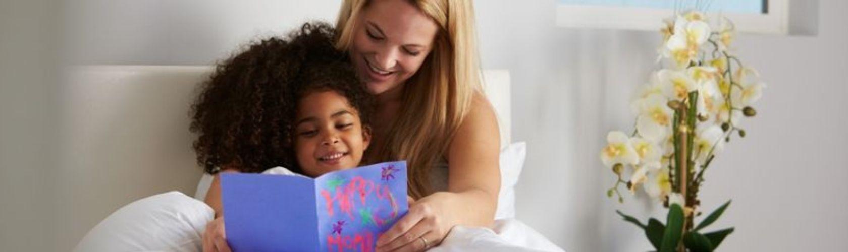Mom & Daughter with card in bed
