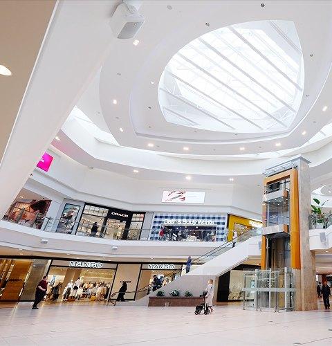 Modern shopping centre interior with retail stores highlighting leasing opportunities