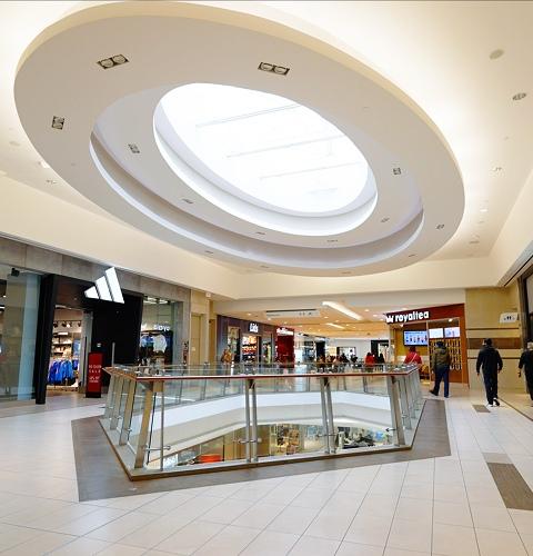 Shopping corridor featuring adidas store with shoppers actively browsing multiple retail outlets