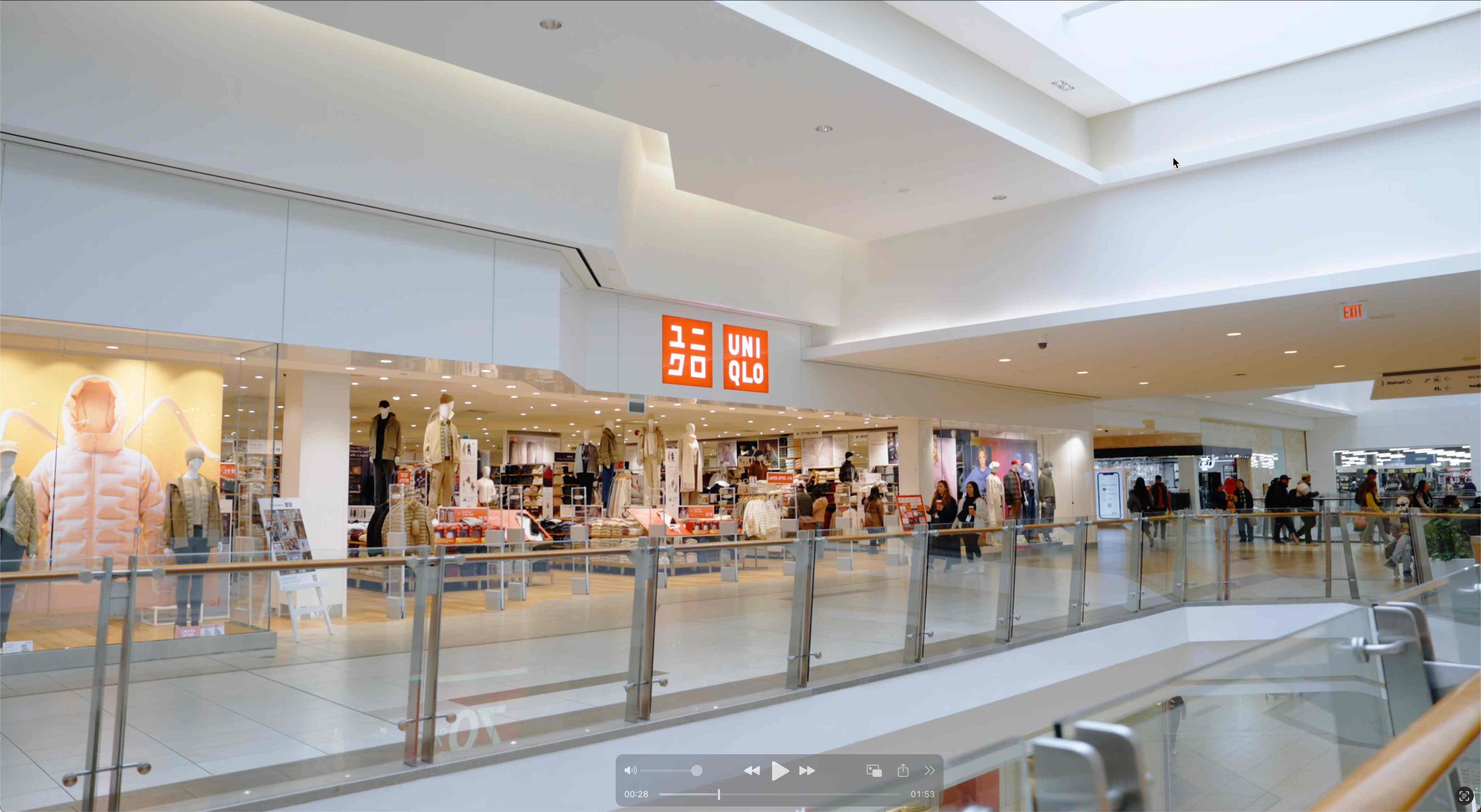 UNIQLO store interior with shoppers browsing clothing and interacting with modern retail displays