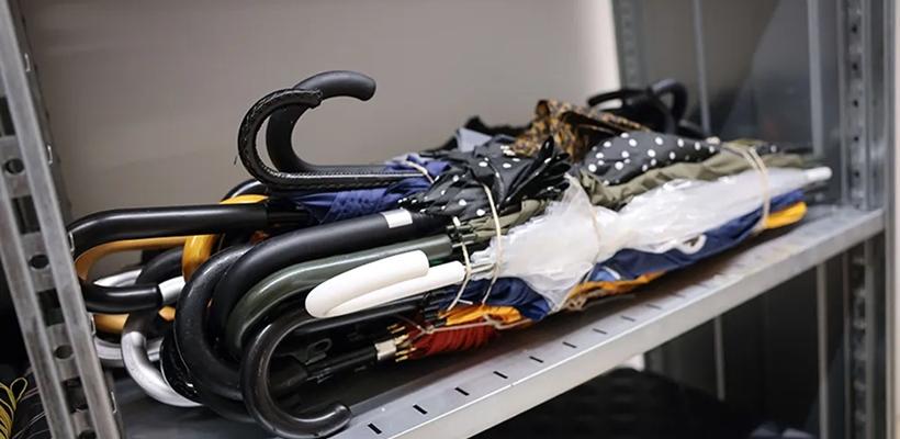 Lost and found items including umbrellas neatly stored at the mall security desk for visitors