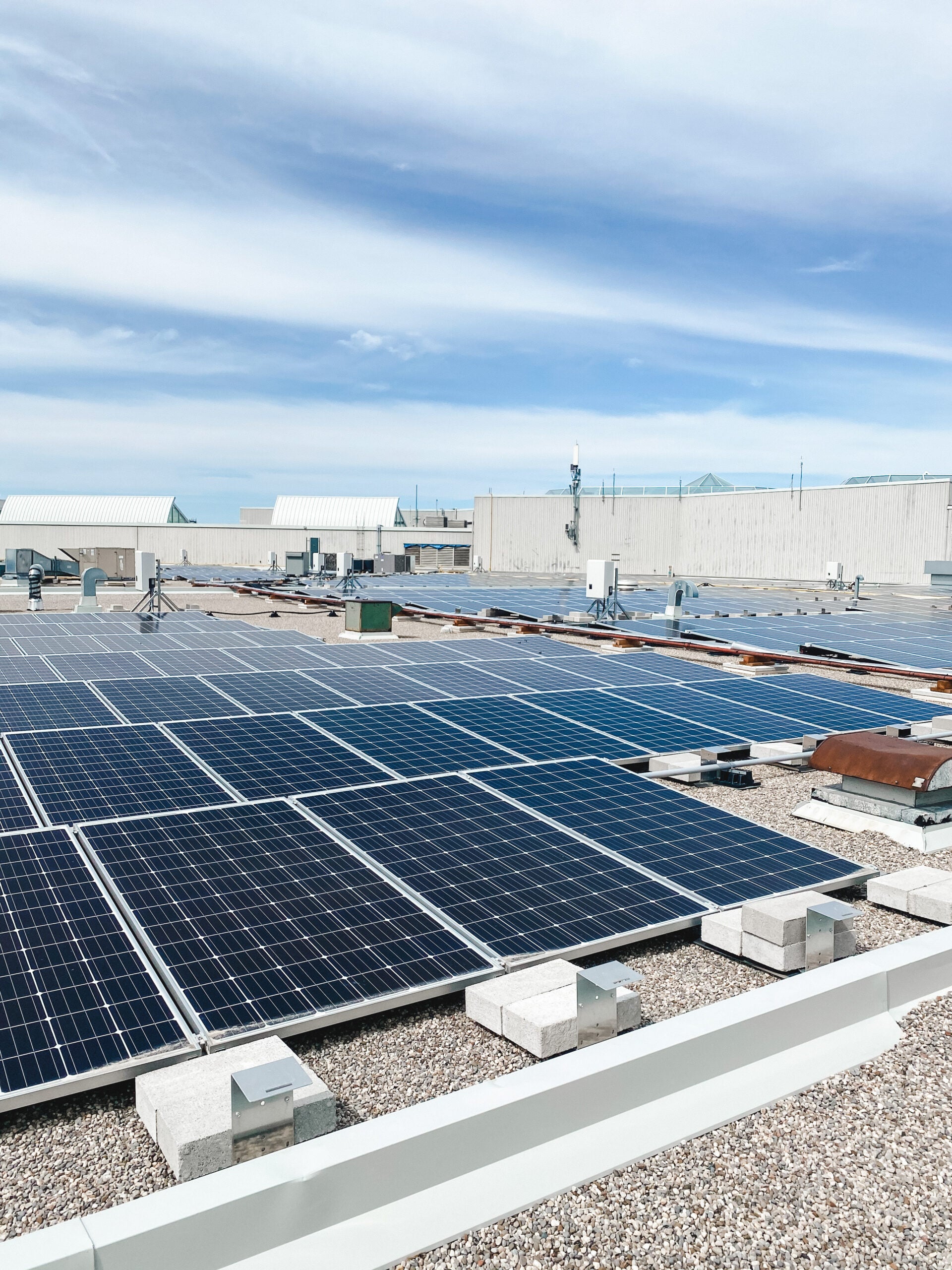 Multiple large solar panels on a rooftop.