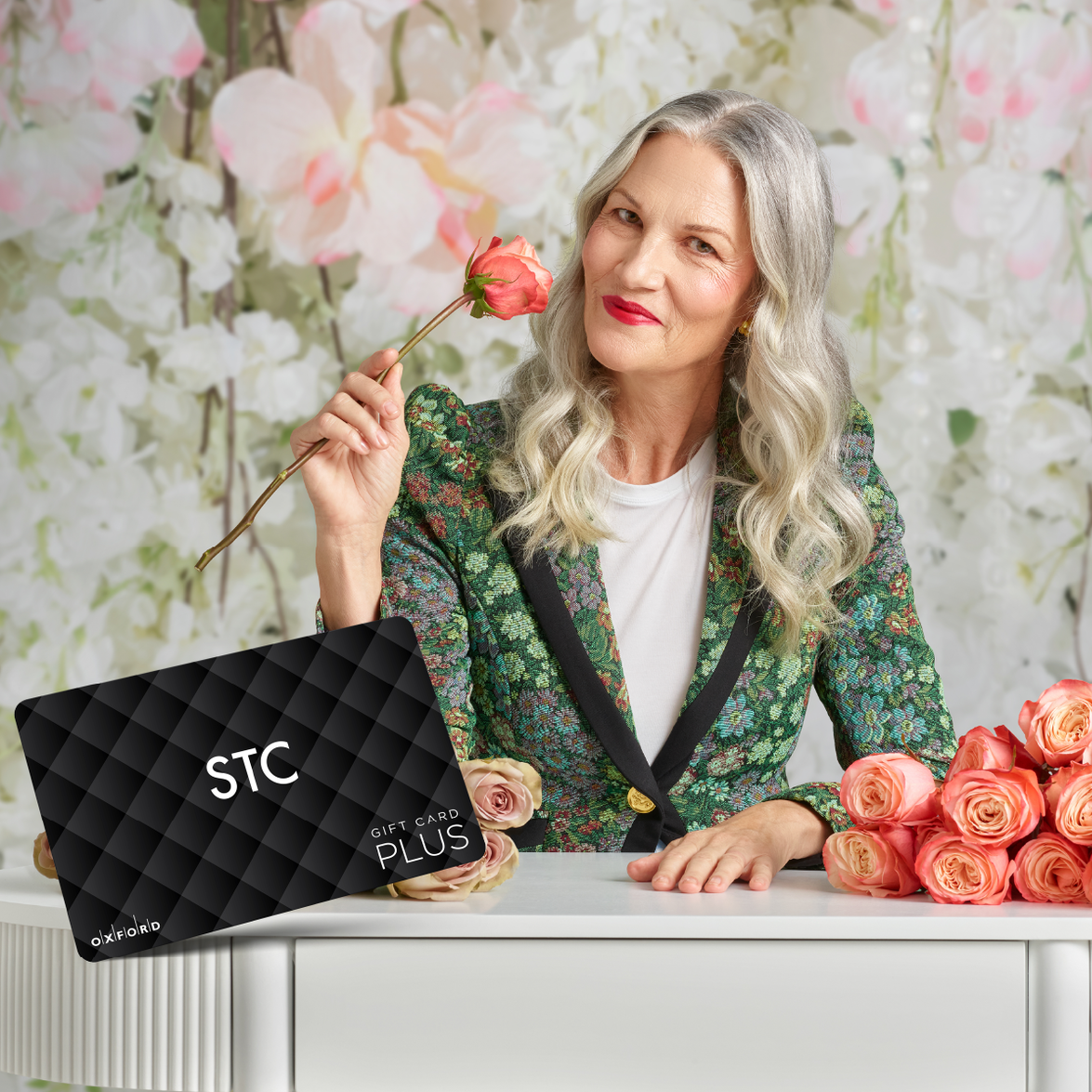 Woman holding roses posing with a gift card from STC