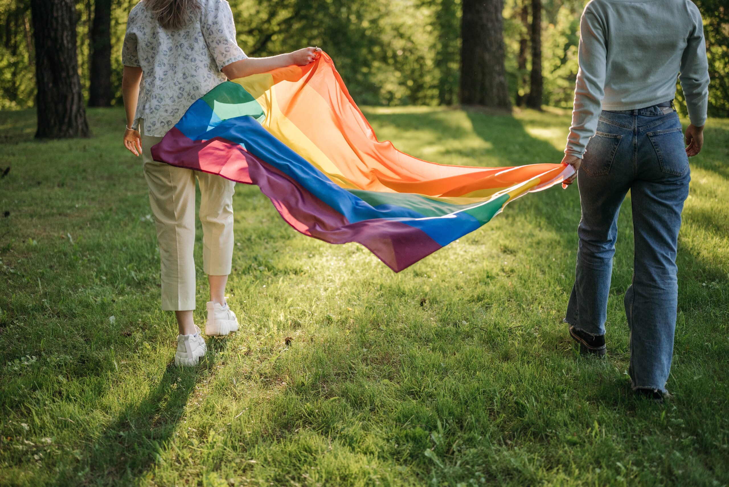 two people holding a pride flag