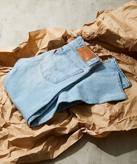 pair of light wash levi's jeans folded atop brown packing paper
