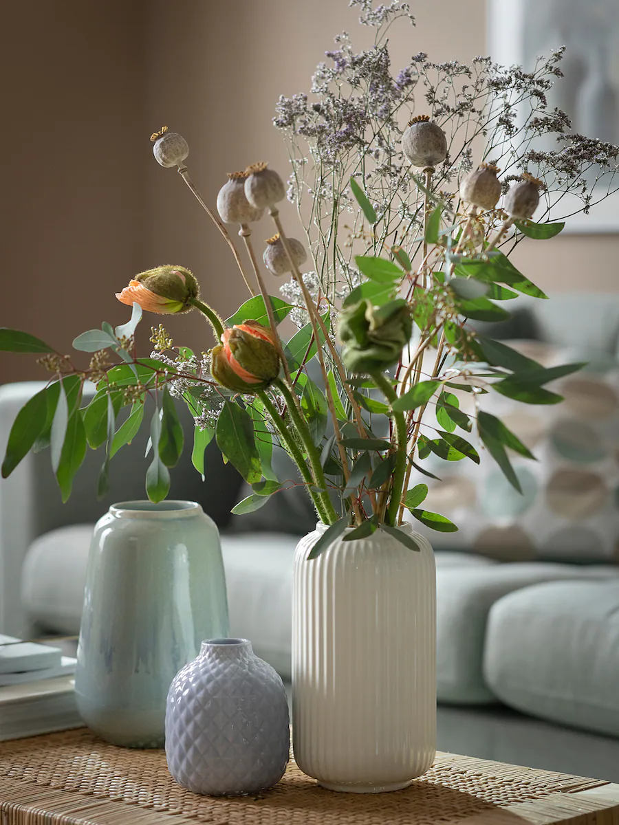 white ceramic vase holding florals in a living room