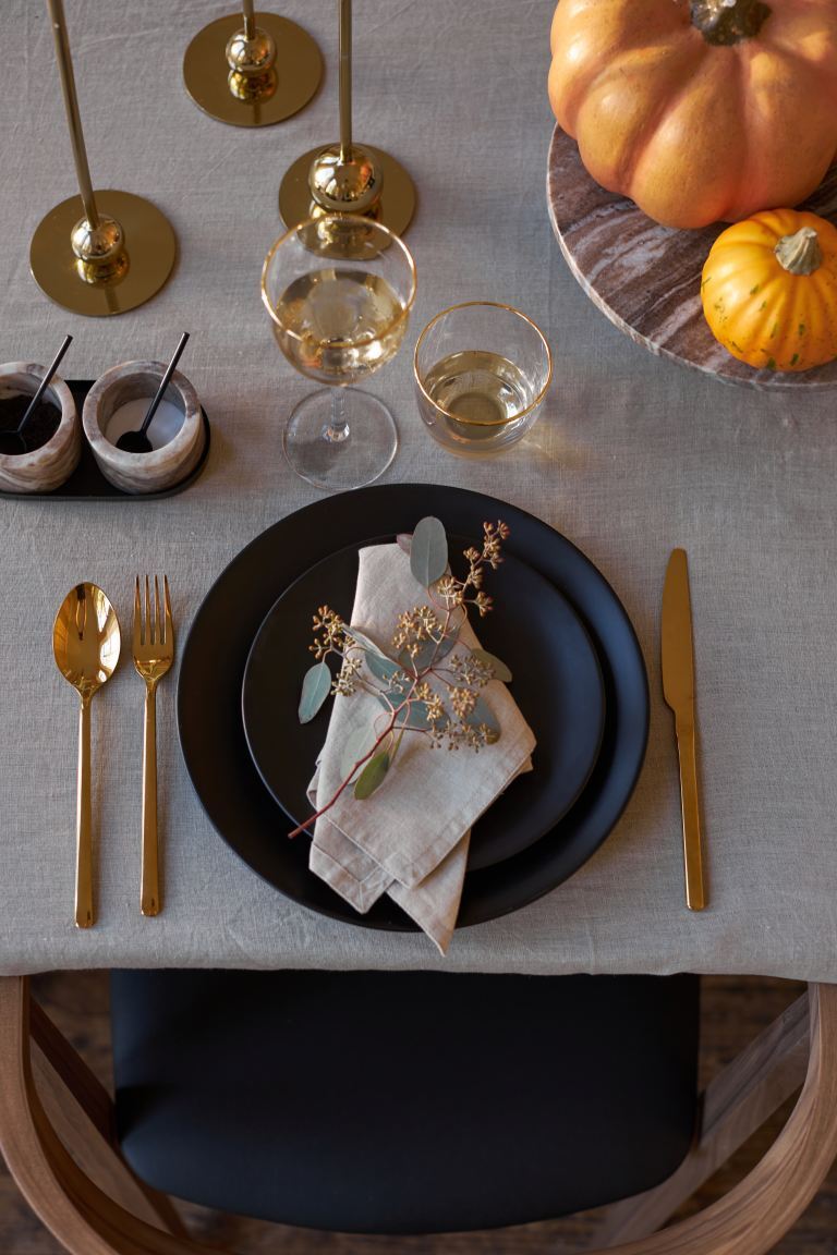 Fall place setting with gold cutlery and navy stoneware plates