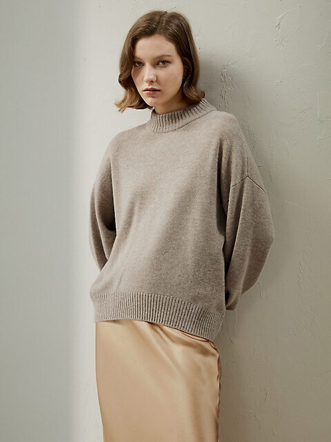 a person modelling an oversized taupe knit sweater