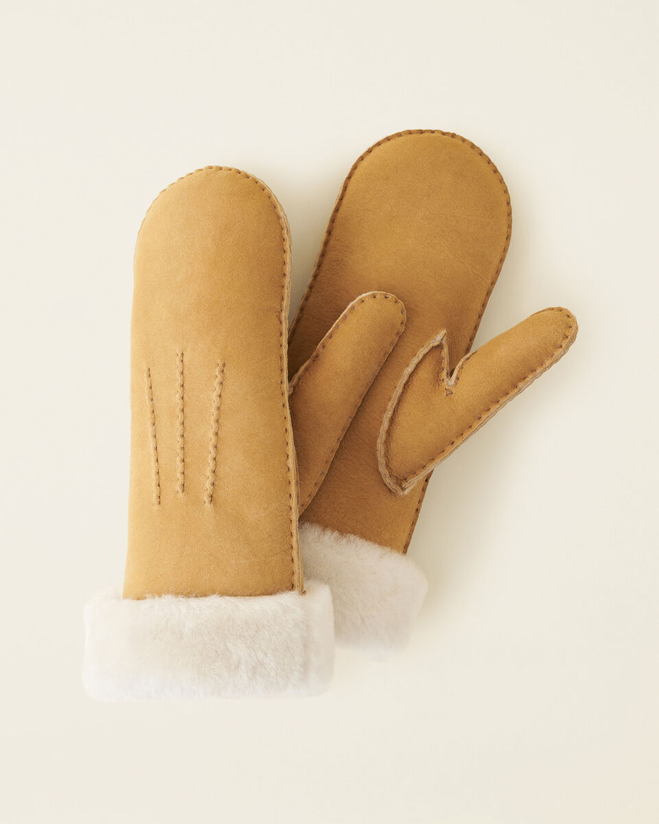 a pair of tan shearling mittens with stitching details