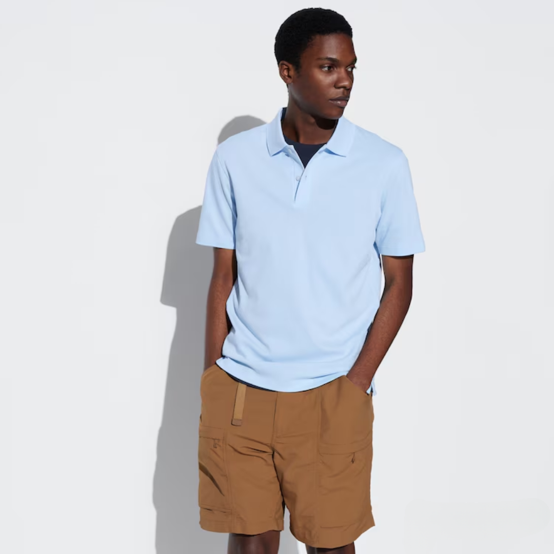 a man wearing a light blue polo with brown shorts
