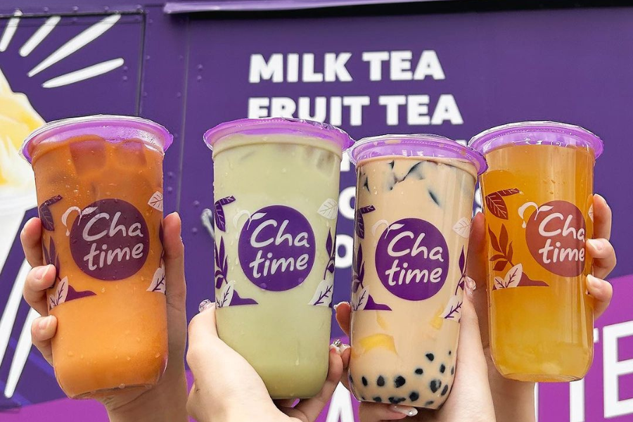 4 chatime drinks being held in front of a food truck