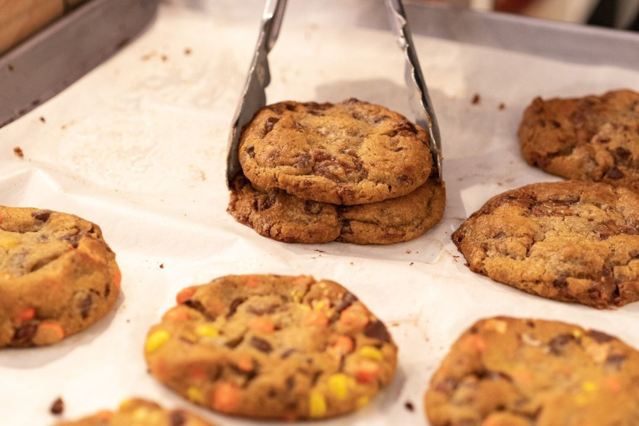 a pair of tongs picking up cookies