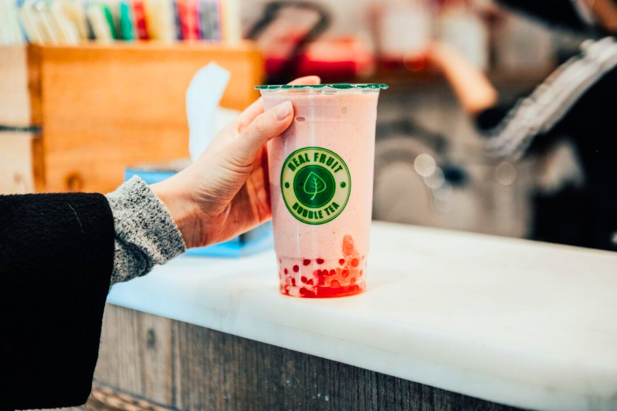 a person holding strawberry bubble tea