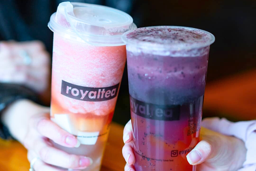 two people with fruit teas in hand doing a cheers