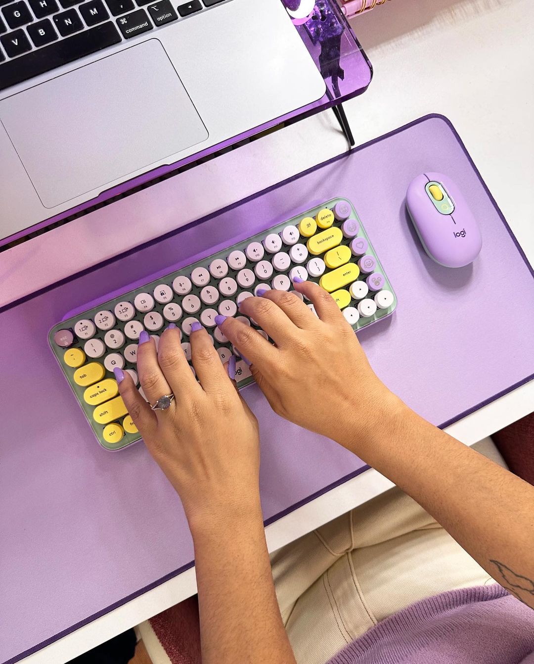 person typing on pastel purple keyboard