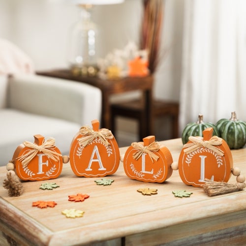 four small wooden pumpkins with individual letters to spell 'fall'