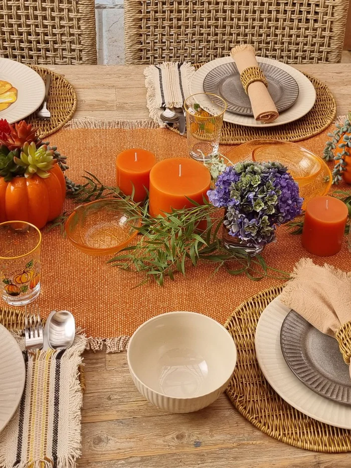 fully set table with orange table runner and candles