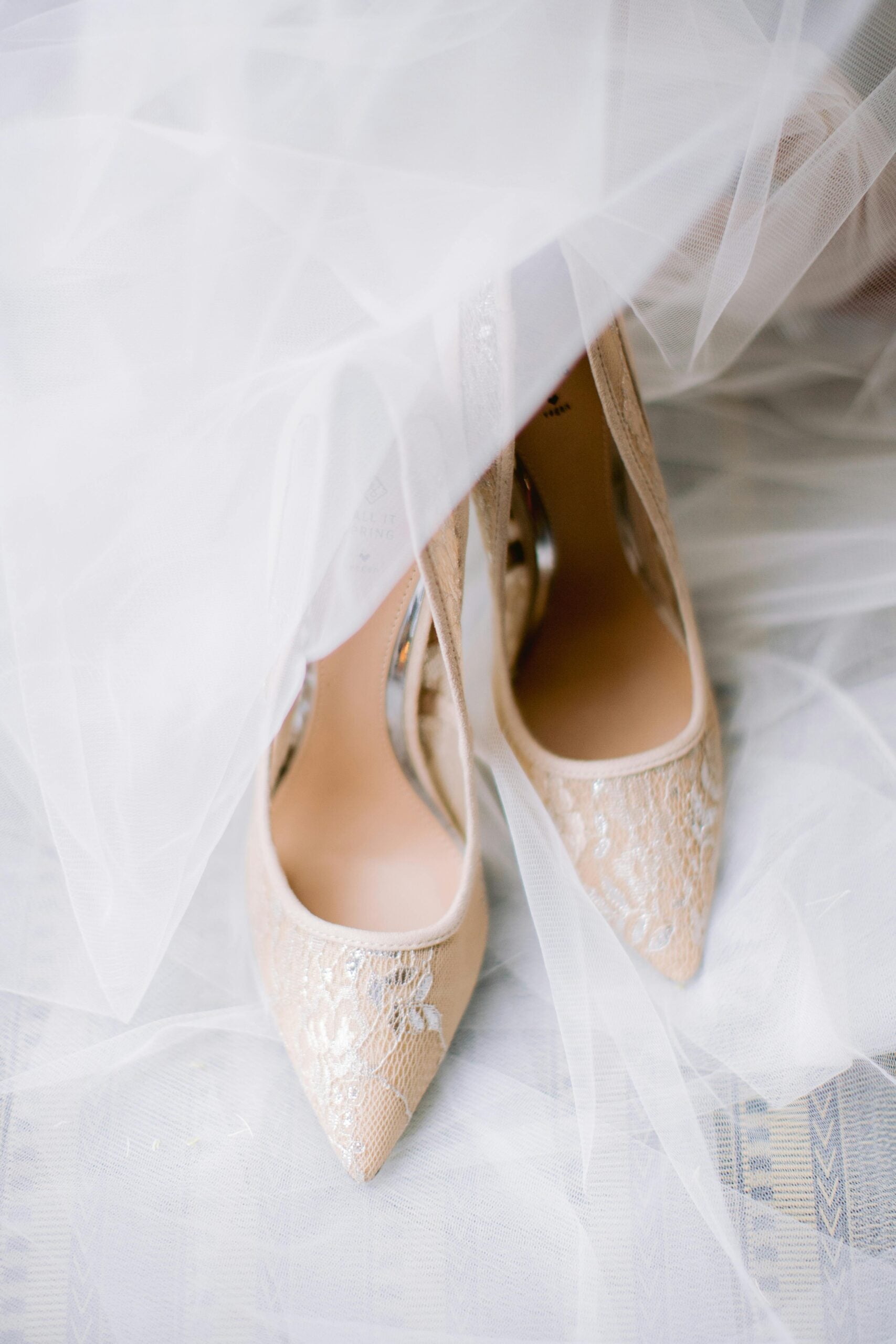 A pair of pointed heels under a wedding dress.