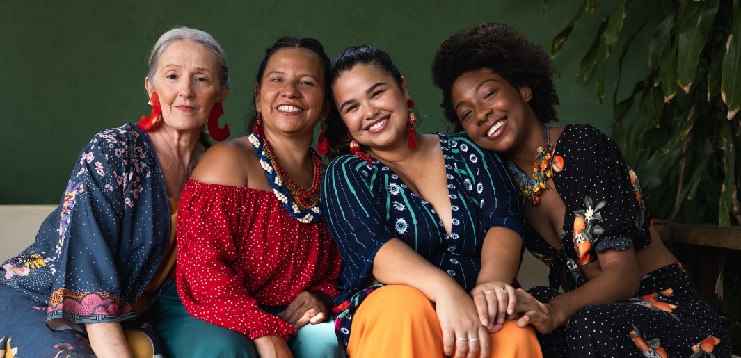 a group of women sitting together smiling