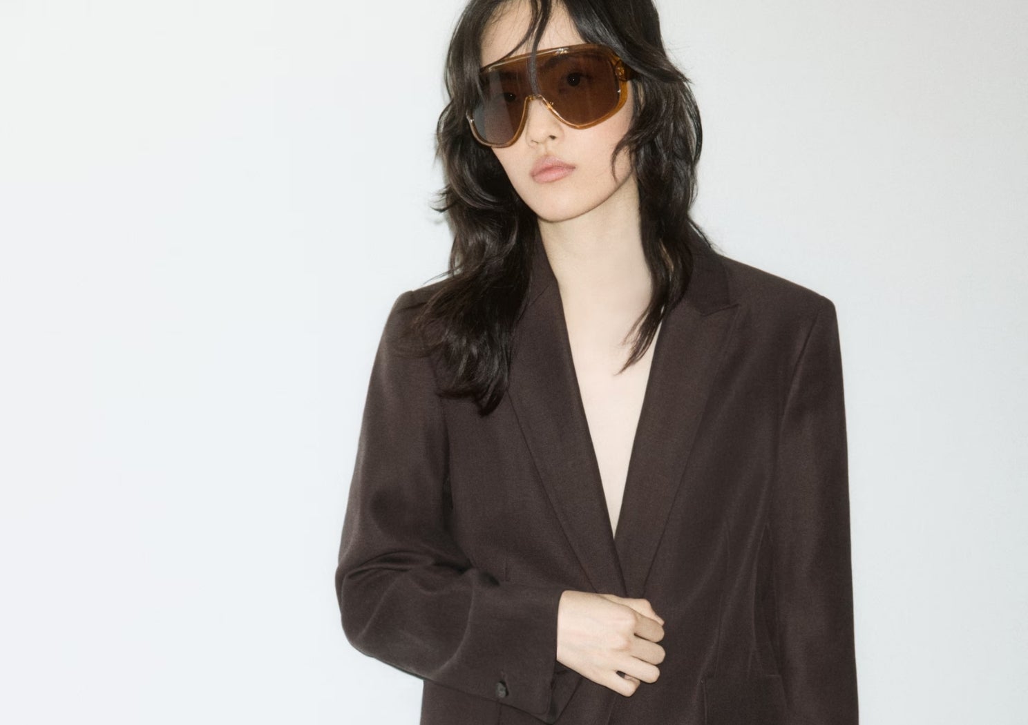 a woman wearing a brown suit