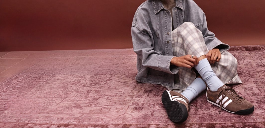 a woman wearing a brown pair of adidas