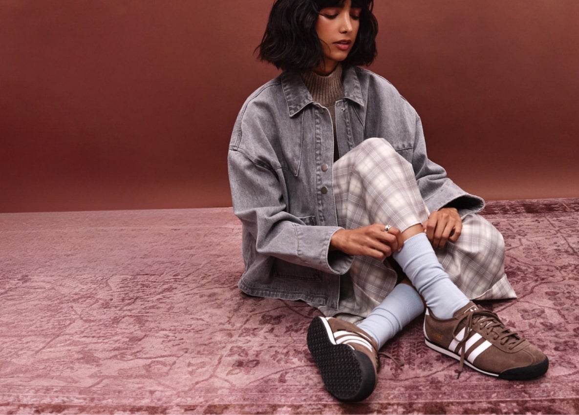 a woman wearing a brown pair of adidas